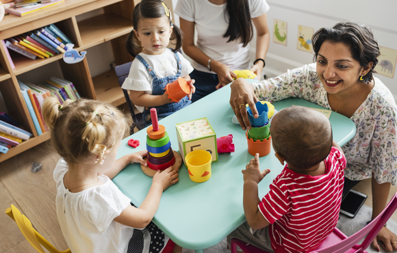 teacher helping four children