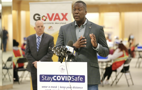 Calvin Ball speaking at mall in columbia mass vax site, governor in background