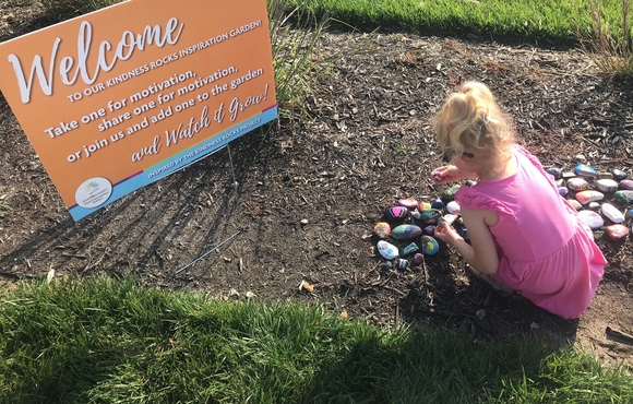 Image of young girl placing painted rocks in the dirt