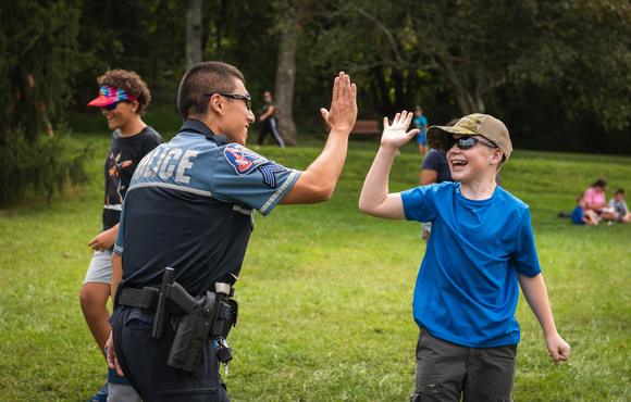 Officer high-fiving a happy child. 