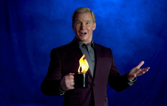 Magician holds coffee mug that is on fire