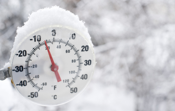 Thermometer covered with snow reading a temperature of negative five degrees.