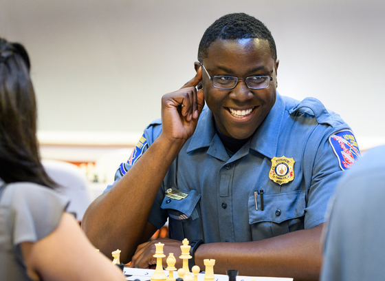 An HCPD officer plays chess at a community event.