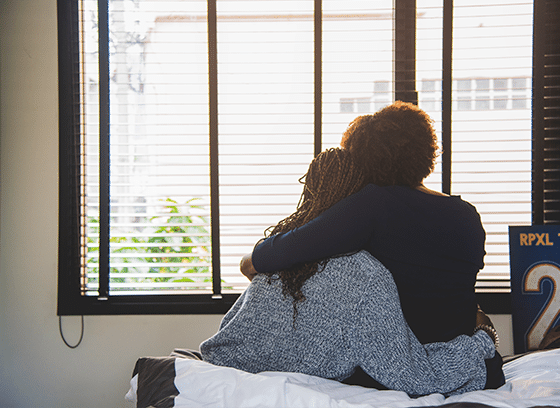 Mother and child hugging while looking out a window