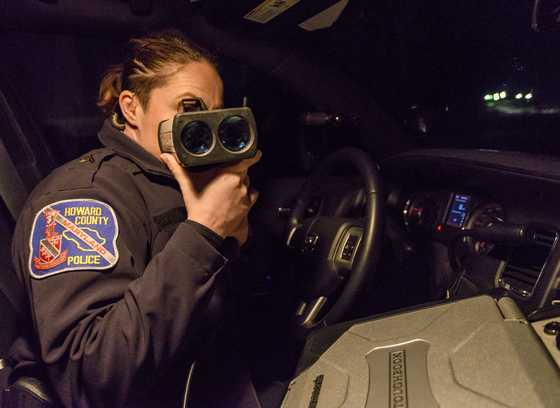 Officer using a radar detector to check a vehicle's speed
