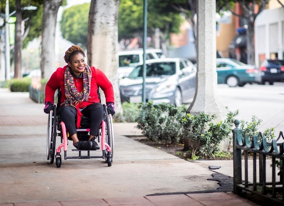 A woman using a wheelchair on the sidewalk