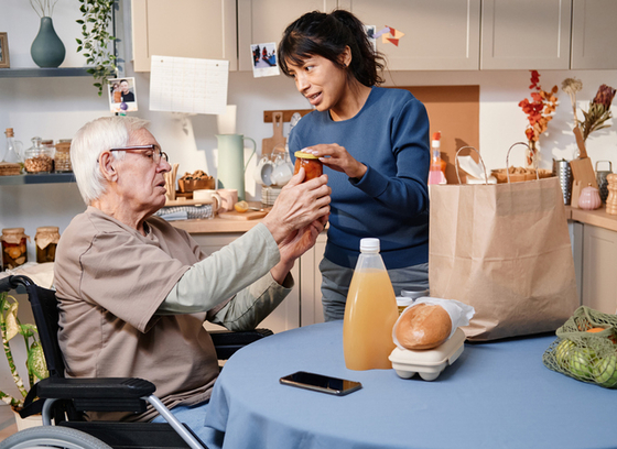 Woman buying food for older adult in wheelchair 