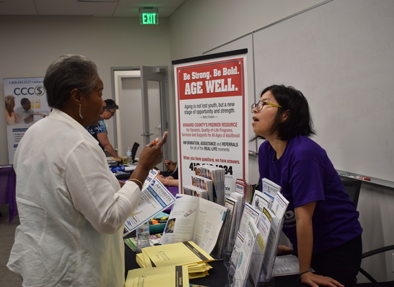 OAI staff member with older adult at a MAP information booth