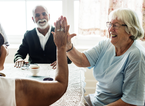 Older Adult female high fiving another person 