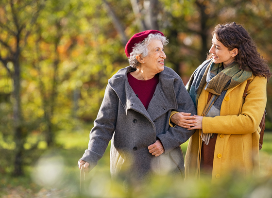 Older female hand in hand with a younger female adult child