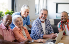 People gathered around a table looking at a computer