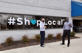 Calvin Ball standing in front of Shop Local sign