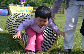 young girl crawling through play tunnel