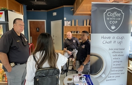 Officers talk to a citizen at Coffee with a Cop