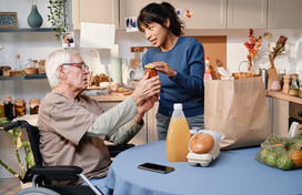 Women buys lunch for older adult in wheelchair