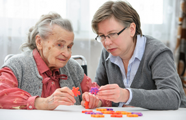 Older adults with carer doing a puzzle 