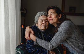 Older adult and caregiver embracing 