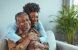 Older adult and caregiver smiling