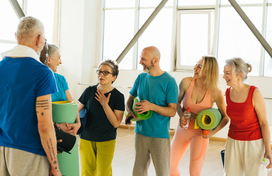 Group of older adults with smile talks about health in gym