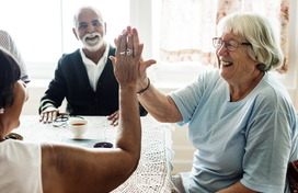 Older Adult female high fiving another person 