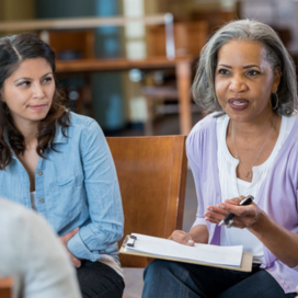 Two women engaged in a discussion group. 